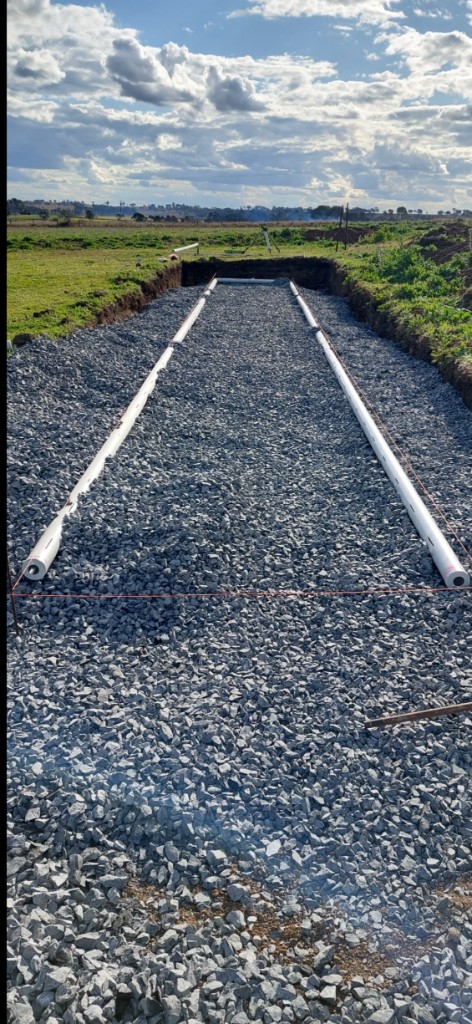Drainage pipes installed in a gravel trench on a rural property
